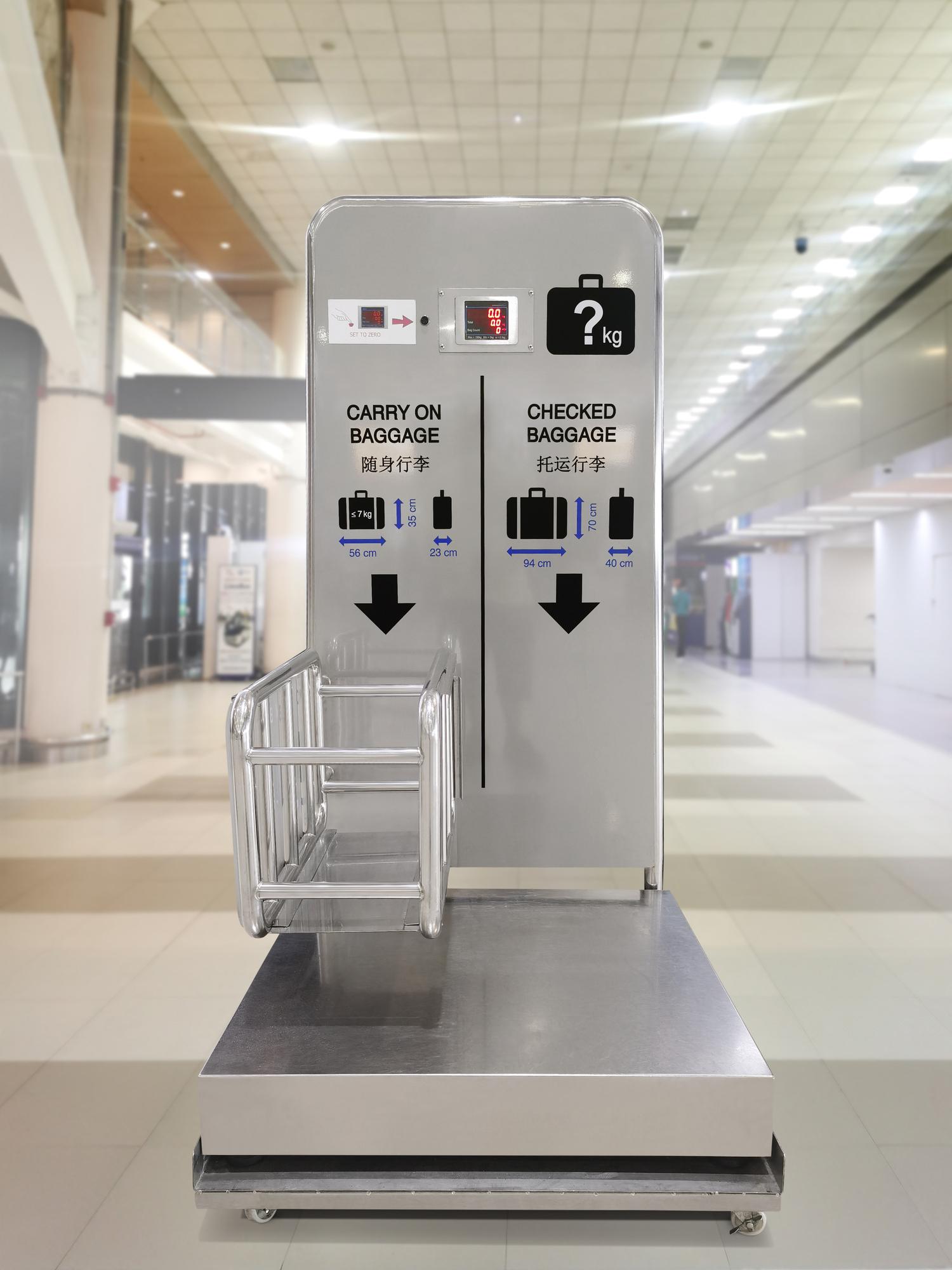 Passenger checking overweight luggage at airport baggage counter